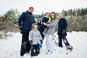 Father and mother with four children in winter nature. Outdoors in snow. photo