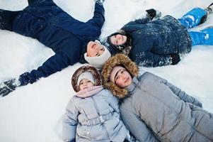 Mother playing with children in winter nature. Outdoors in snow. photo