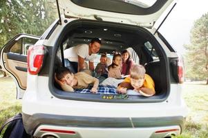 Family kids at vehicle interior. Children in trunk. Traveling by car in the mountains, atmosphere concept. Happy parents. photo