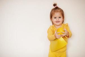 Baby girl in yellow with lemon and card, isolated background. photo