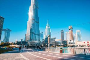 vista del burj khalifa en un hermoso día con el reflejo del sol junto a las fuentes. foto