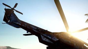 old rusted military helicopter in the desert at sunset photo