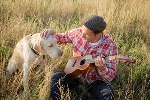 yong man toca el ukelele al aire libre foto