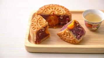 chinesischer mondkuchen lila süßkartoffel- und eigelbgeschmack mit tee auf holzplatte video