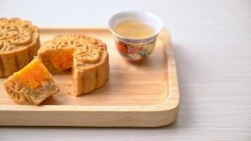 gâteau de lune chinois durian et saveur de jaune d'oeuf avec thé sur plaque de bois video