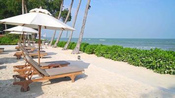 Regenschirm mit Strandkorb und Ozean-Meer-Hintergrund - Urlaubs- und Urlaubskonzept