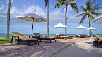 umbrella with bed pool around swimming pool with ocean sea background - holiday and vacation concept video