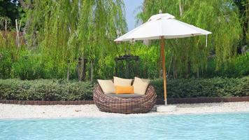 guarda-chuva com piscina de cama ao redor da piscina - conceito de férias e férias
