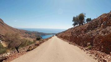 Vehicle POV drive. Car Travel point of view road to the mediterranean sea. Coastline nature, steep rocky slopes and sunny blue sky, asphalt road. Vacation, trip, journey blog concept video