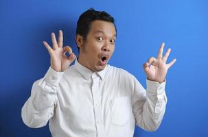 Young Asian businessman shows okay OK sign. photo