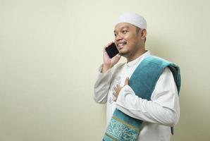 Asian Muslim man looks happy when receiving a call from his brother photo