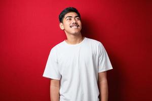 Young handsome man looking away to side with smile on face, natural expression photo