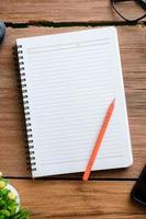 Top view of wooden table and stationery with copy space, flat lay. photo