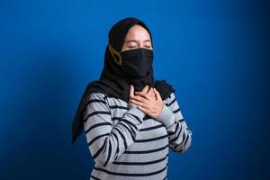 Asian muslim college student girl wearing mask feeling pain in her chest photo