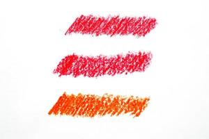 crayón abstracto sobre fondo blanco. textura de garabato de crayón rojo. mancha de pastel de cera. es un dibujo a mano foto