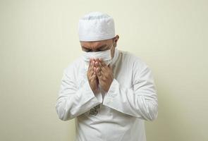 Fat Asian Muslim men wearing a mask coughing photo