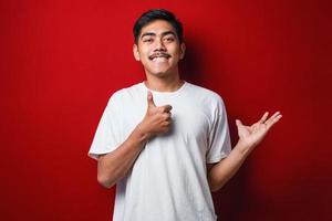 Young handsome man wearing casual shirt showing palm hand and doing ok gesture with thumbs up photo