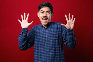 Handsome young man wearing casual clothes showing and pointing up with fingers number ten while smiling confident and happy photo