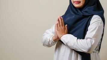 Asian Muslim women wearing hijab gesturing to welcome guests photo