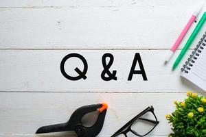 Q and A text over wooden table, business concept photo