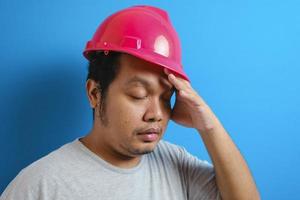 trabajador asiático gordo con camiseta gris y casco de seguridad foto