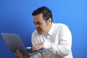 Portrait of young Asian businessman typing on laptop photo