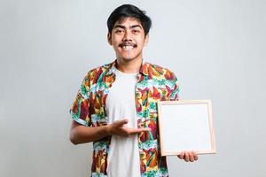 Young asian man holding blank letterboard pointing with finger to the camera and to you photo