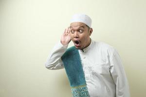 Fat asian muslim man listen whispers with funny face photo