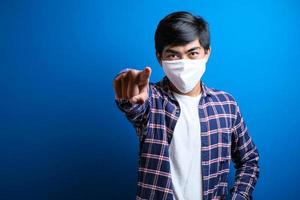 Happy asian man smiles looked at camera against blue background photo