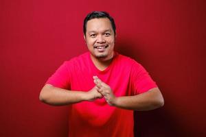 Asian man smiles looking to camera with chinese greeting gesture photo