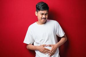 Asian man waring casual shirt diarrhea health problems hold his belly photo