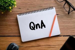Q and A text over wooden table, business concept photo