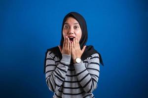 Asian muslim girl wearing hijab shows surprised or shocked expression with open mouth photo