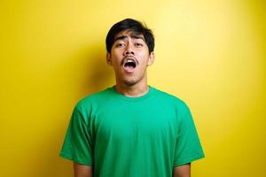 cara conmocionada del hombre asiático en camiseta verde foto