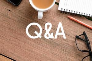 Q and A text over wooden table, business concept photo