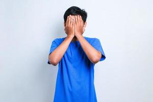 Asian man with sad expression covering face with hands while crying. depression concept photo