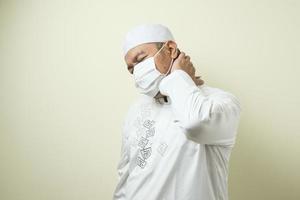 a asian muslim fat guy wearing mask feeling pain photo