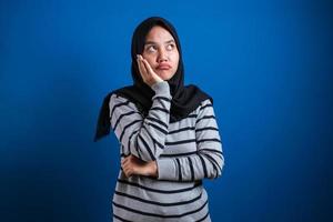 Portrait of angry cynical Asian muslim woman with suspicious expression looking at camera photo