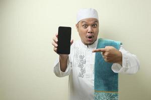 Fat Asian Muslim men looks surprised at the good news on phone photo