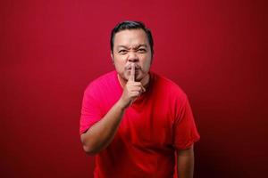 Serious strict man holding finger near lips, showing shh gesture asking to keep silence and be quite photo