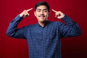 Handsome young man wearing casual shirt smiling pointing to head with both hands finger, great idea or thought, good memory photo