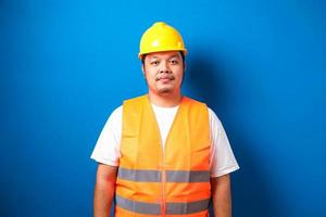 Asian guy wearing helmet and savety vest smiles at the camera photo