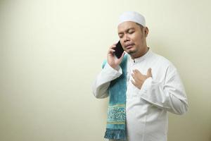 Asian Muslim man looks sad while receiving phone photo