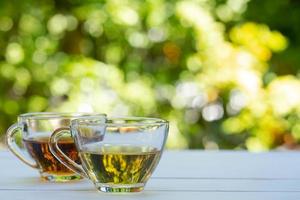 tazas de té verde y chino en una mesa blanca en el jardín foto