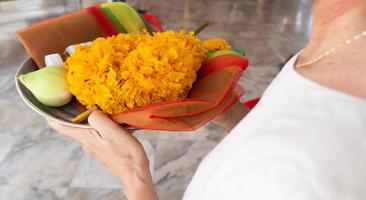 Senior buddhist asian woman is praying in temple photo