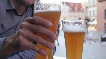 l'uomo beve birra seduto al tavolo del ristorante di strada nella vecchia città europea video