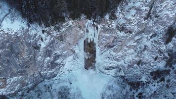 vista aérea de drones de cascada congelada con un poco de agua corriendo. hermoso y mágico paisaje de vacaciones de invierno para los amantes de la naturaleza. paisaje fuera del mundo de narnia. turismo inimaginable de cuento de hadas. video
