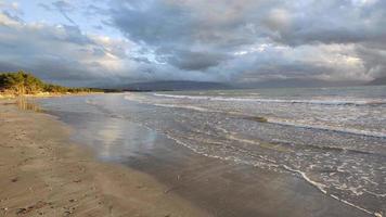 Beautiful sunset at a beach with the waves flowing. Calm and relaxing feeling. Golden light of the sun. Holidays are coming. Clouds passing in the sky. Vibrant colors. Vacations next to the sea. video