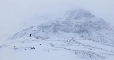 alpinista solo apanhado em uma forte nevasca em um dia de inverno. vento muito forte e neve caindo. condições exigentes e difíceis para caminhadas de inverno em condições climáticas ferozes na montanha video