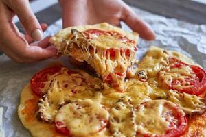 Woman hand takes a slice of pizza slice photo